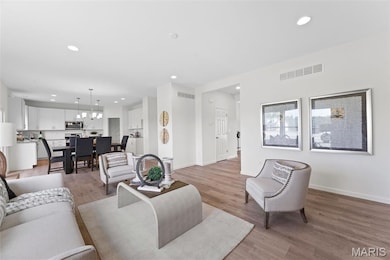 Living room featuring light wood-style flooring and recessed lighting
