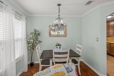The dining area is adjacent to the living and kitchen areas.  Note the ornamental light fixture.