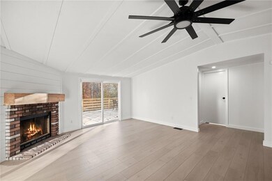 Unfurnished living room featuring lofted ceiling w