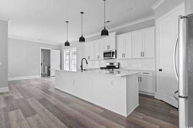 Kitchen with a kitchen island with sink, white cab