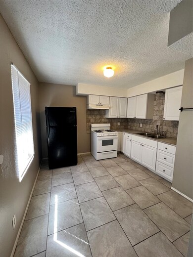 Kitchen featuring range hood, refrigerator, taste