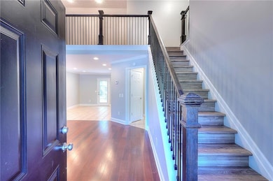Entrance foyer featuring stairway, wood finished floors, recessed lighting, crown molding, and a high ceiling