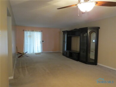 Living room with ceiling fan, slider door to brand
