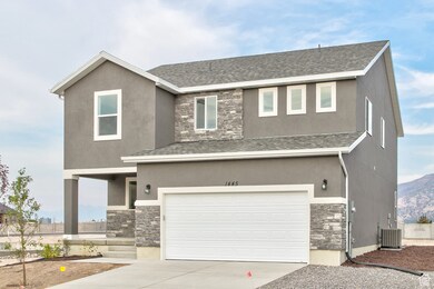View of front facade with stone siding, concrete driveway, a garage, and stucco siding