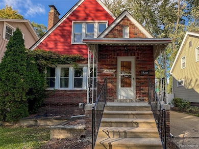 View of front of property featuring brick siding, a chimney, and a porch