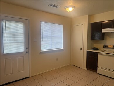 Kitchen featuring white range with electric cookto