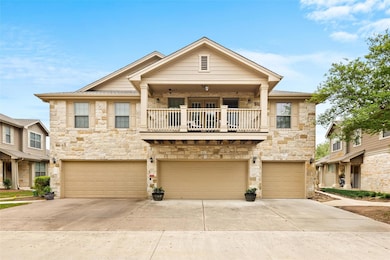 View of property featuring stone siding, a balcon