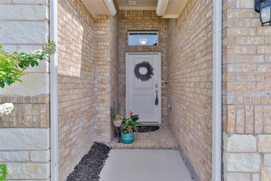 View of exterior entry with brick siding