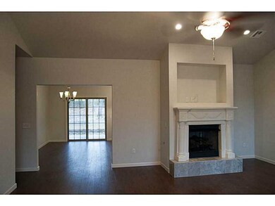 Living Room. A large living room has a vaulted ceiling, fireplace and hardwood flooring.