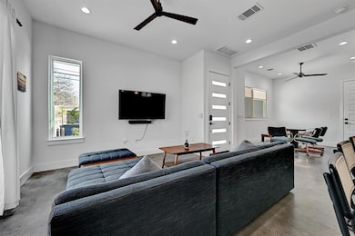 Living room with concrete floors, visible vents, 