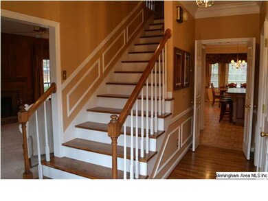 Elegant foyer with gleaming hardwood floors & stai