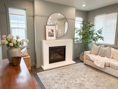 Living area featuring wood finished floors, a glass covered fireplace, and recessed lighting