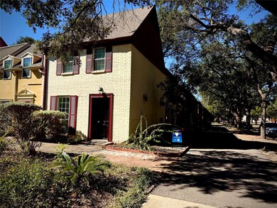 Charming townhouse with classic brick facade, nestled among mature trees for a serene setting.