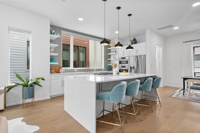 Kitchen with white cabinetry, open shelves, a kit