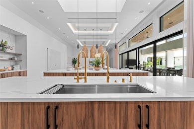Black and brass accents throughout the home create a contemporary modern feel. Seen above is one of the impressive dual island kitchens with four foot sink.