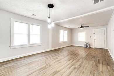 Unfurnished living room featuring ceiling fan, a t
