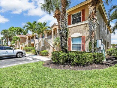View of property with uncovered parking, stairway, stucco siding, and a front lawn