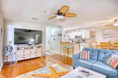 Living room with ceiling fan, a textured ceiling, 