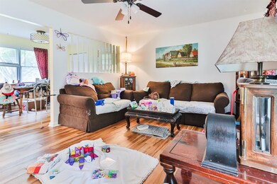 Living room with wood-type flooring and ceiling fa