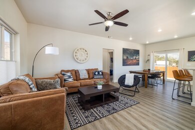 Living room featuring light wood-type flooring, a ceiling fan, and recessed lighting