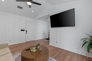 Living room featuring a ceiling fan, light wood-s