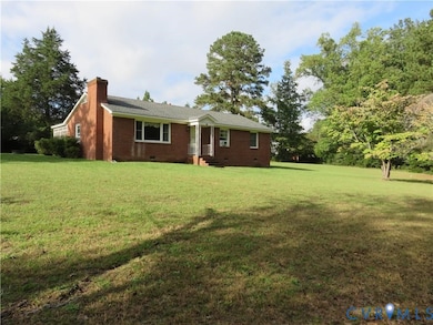 Ranch-style house featuring a chimney, crawl space, brick siding, and a front lawn