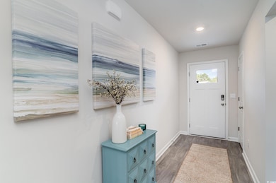 Entryway with wood finished floors and recessed lighting