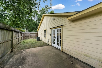 Concrete patio on side with double French doors
