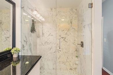 Bathroom featuring a shower stall and vanity