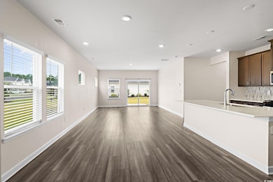 Unfurnished living room with dark wood-style flooring and recessed lighting
