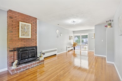Living room with brick fireplace wood burning stove and hardwood floors East Hartford home