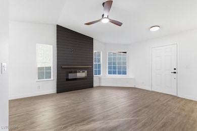 Living room with vaulted ceiling, wood finished floors, and ceiling fan
