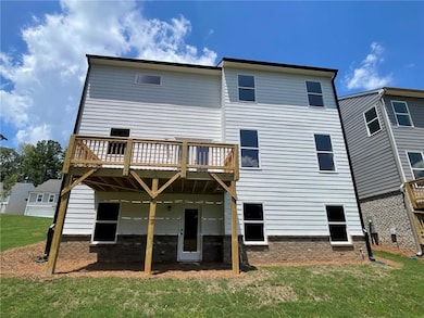 Rear view of property featuring a deck and a lawn