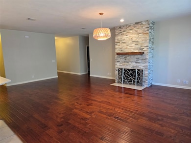 Unfurnished living room with a stone fireplace an