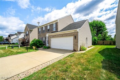 View of front of house featuring brick siding, a residential view, driveway, and a garage