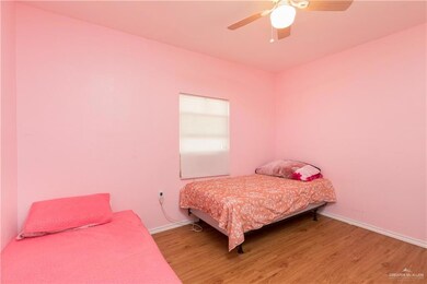 Bedroom with baseboards, light wood-style flooring, and ceiling fan