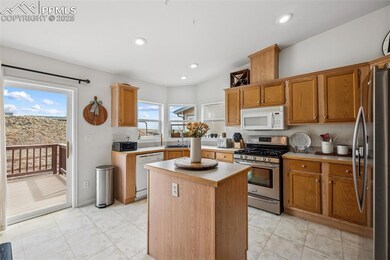 Kitchen featuring light countertops, recessed lighting, a kitchen island, a sink, and appliances with stainless steel finishes