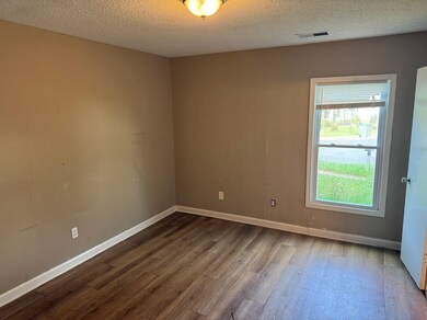 Empty room with dark wood-style floors and a textured ceiling
