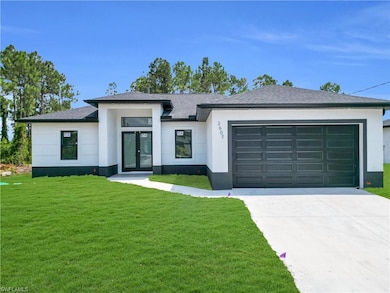 View of front facade with french doors, a garage, a front lawn, and stucco siding