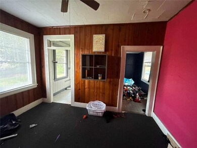 Carpeted spare room with ceiling fan and wood walls