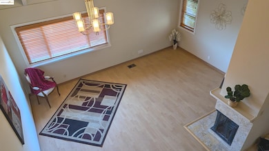Dining area with a chandelier, wood finished floors, and a multi sided fireplace