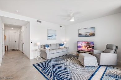 Living room featuring ceiling fan and light tile p