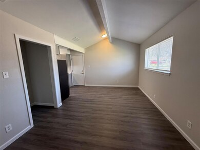 Empty room with lofted ceiling with beams, basebo
