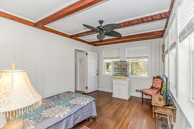 Bedroom featuring beamed ceiling, wood finished fl