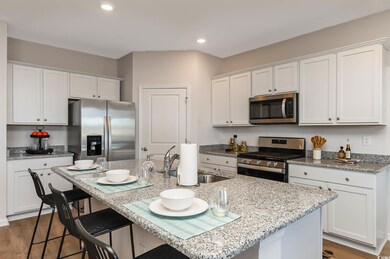 Kitchen featuring a kitchen island with sink, whit