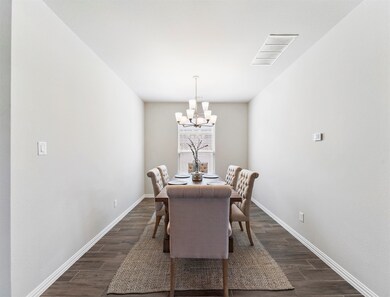 This incredibly elegant formal dining room features gorgeous wood-look tile floors, a beautiful chandelier, and is the perfect place for a nice evening dinner with family, friends, and guests.