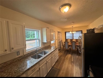 Kitchen with white cabinetry, hardwood / wood-styl