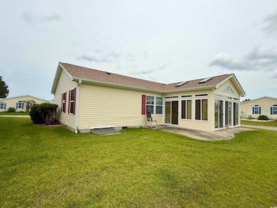 Rear view of property featuring a patio area, a lawn, crawl space, and roof with shingles