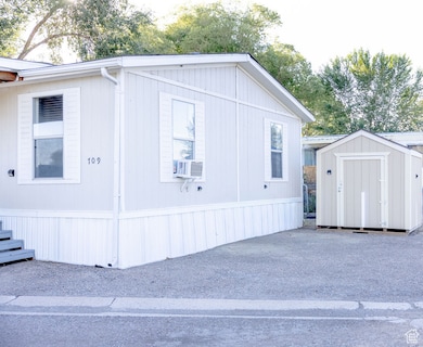 View of side of property with a storage shed