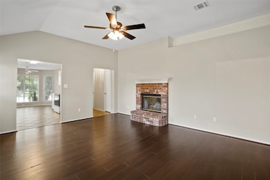Unfurnished living room featuring a fireplace, ceiling fan, lofted ceiling, and dark wood-style floors